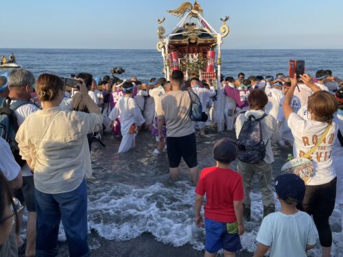 浜降祭のみそぎを波打ち際から見守る観客と神輿の様子