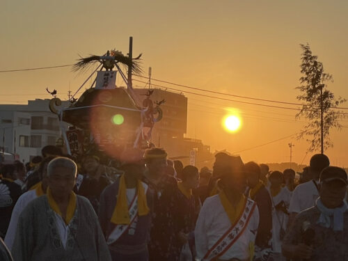 朝焼けの茅ヶ崎西浜海岸で神輿と担ぎ手が集まる浜降祭の様子